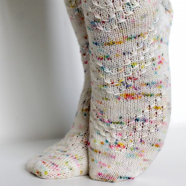 A speckled pair of socks with a textured chevron pattern