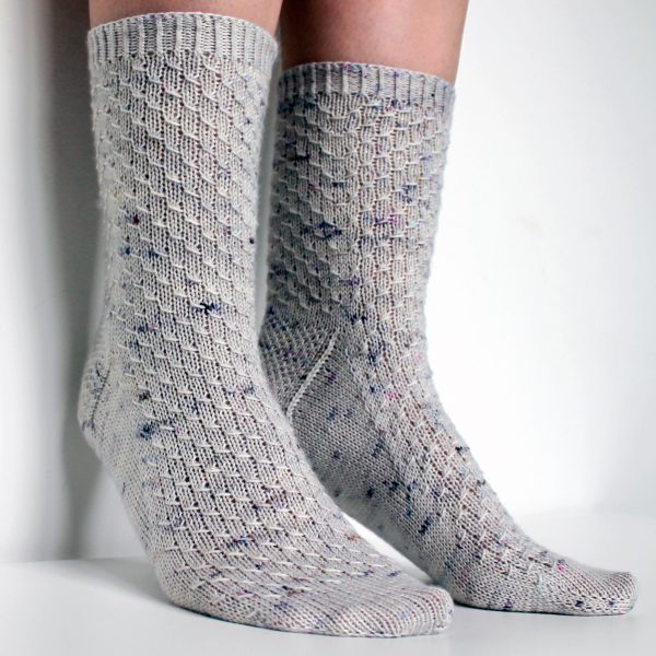 Grey speckled socks with an all-over textured pattern mirrored on each foot