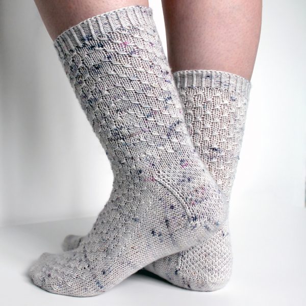 Grey speckled socks with an all-over textured pattern mirrored on each foot