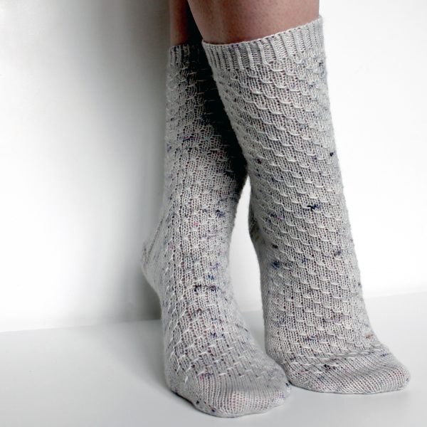 Grey speckled socks with an all-over textured pattern mirrored on each foot