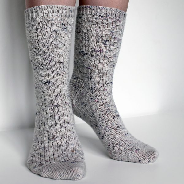 Grey speckled socks with an all-over textured pattern mirrored on each foot