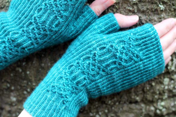 Twisted rib fingerless mitts with a smocked faux cable trellis patter asymmetrically on the back of the hand