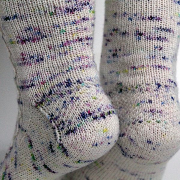 Speckled socks with a slipped stitch cable pattern up the outside of the foot