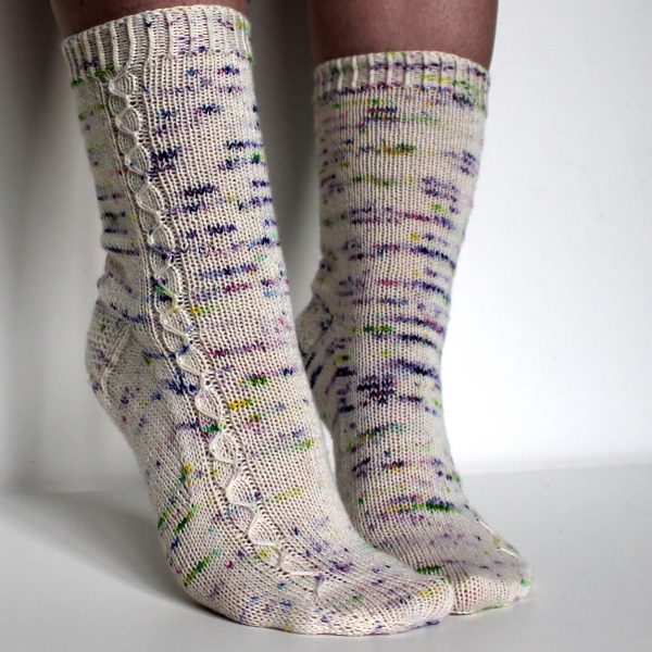 Speckled socks with a slipped stitch cable pattern up the outside of the foot