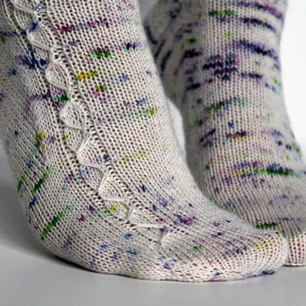 Speckled socks with a slipped stitch cable pattern up the outside of the foot