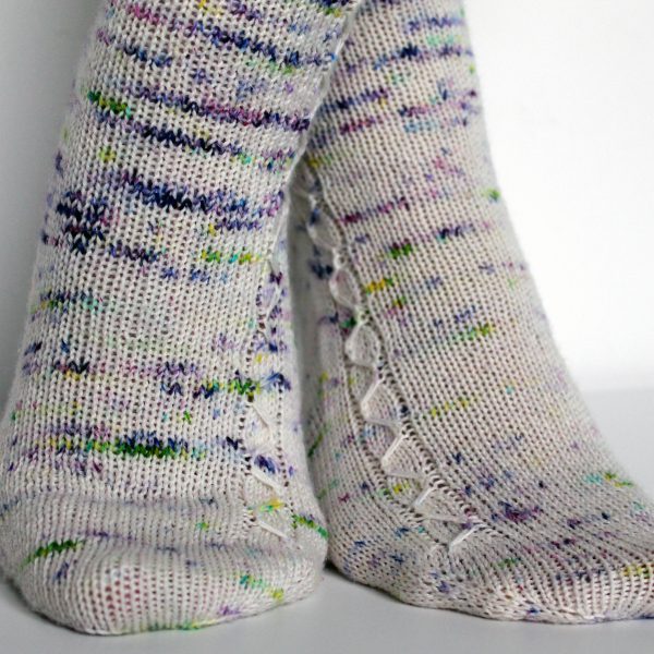 Speckled socks with a slipped stitch cable pattern up the outside of the foot