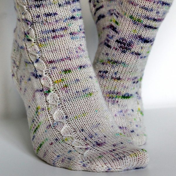 Speckled socks with a slipped stitch cable pattern up the outside of the foot