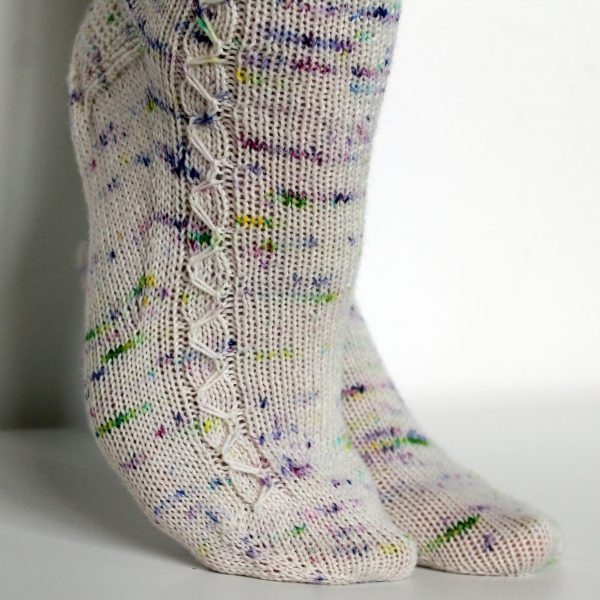 Speckled socks with a slipped stitch cable pattern up the outside of the foot