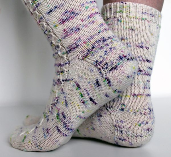 Speckled socks with a slipped stitch cable pattern up the outside of the foot