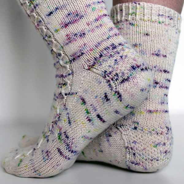 Speckled socks with a slipped stitch cable pattern up the outside of the foot