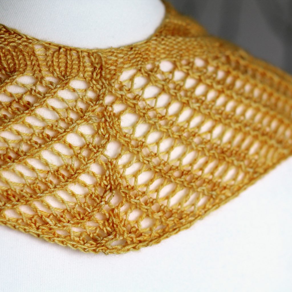 A yellow cowl with a ribbed body and wide lace border