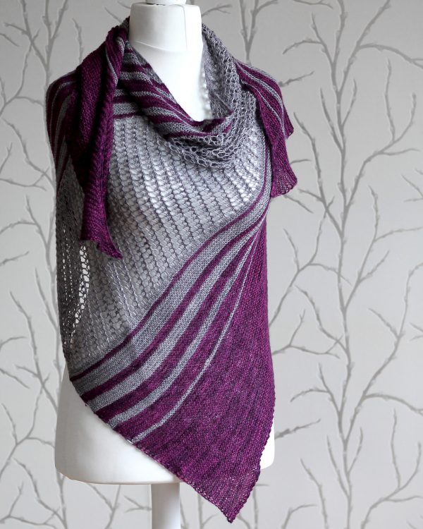 A purple and grey striped shawl with lace panels draped around a mannequin