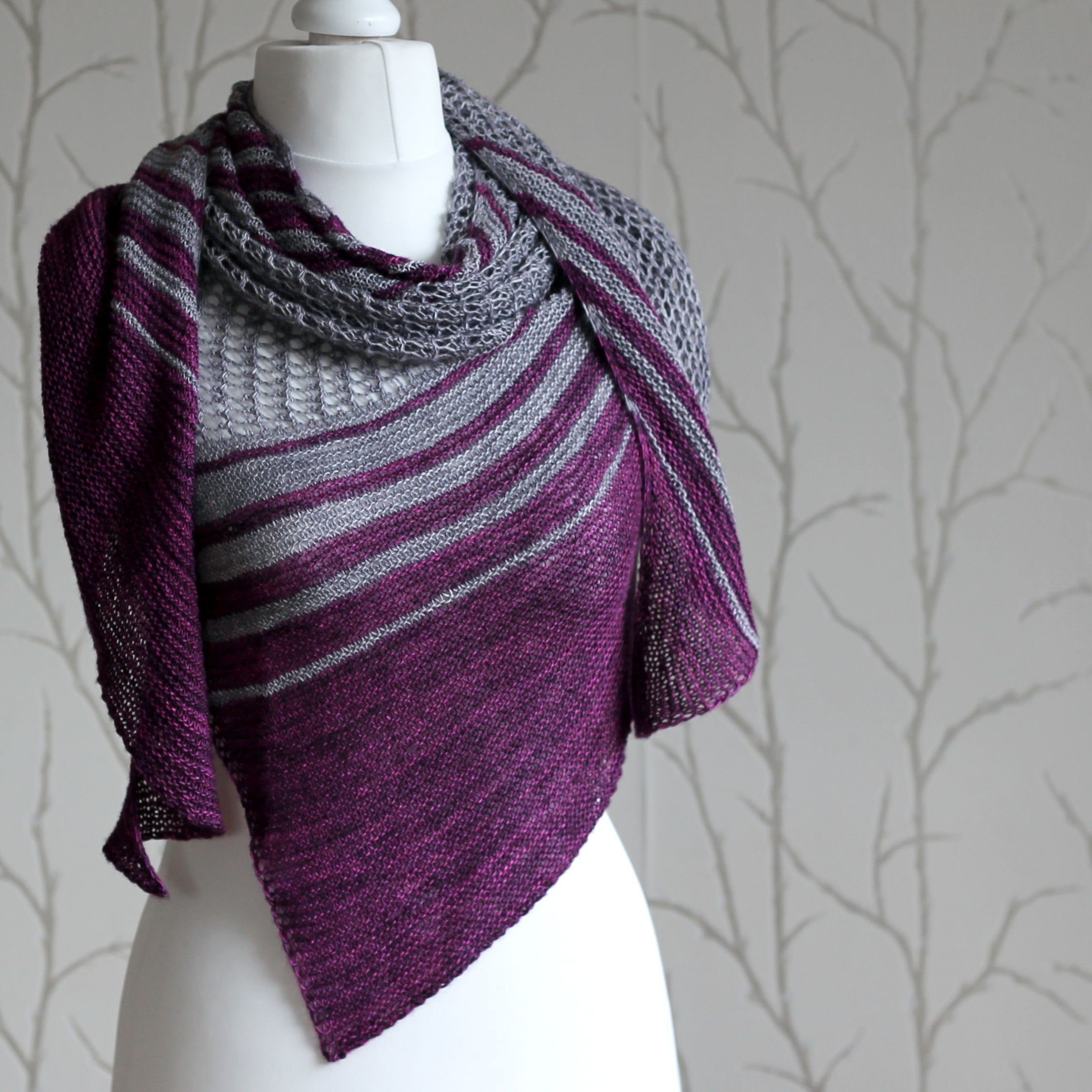 A purple and grey striped shawl with lace panels draped around a mannequin