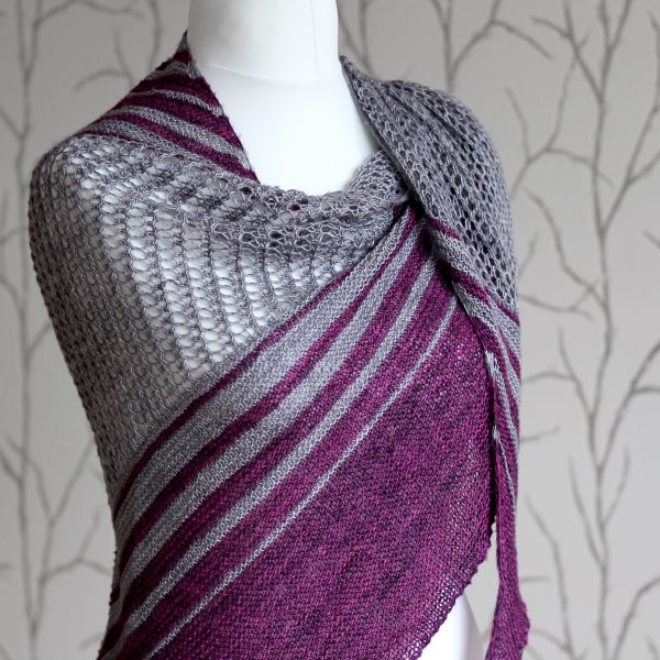 A purple and grey striped shawl with lace panels draped around a mannequin