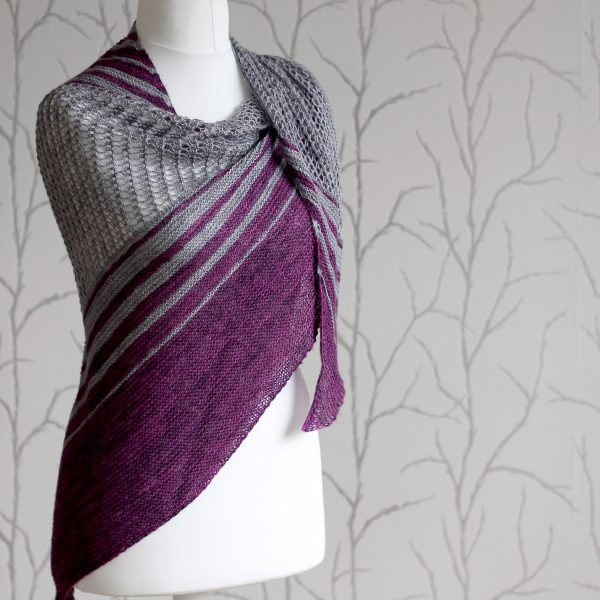 A purple and grey striped shawl with lace panels draped around a mannequin