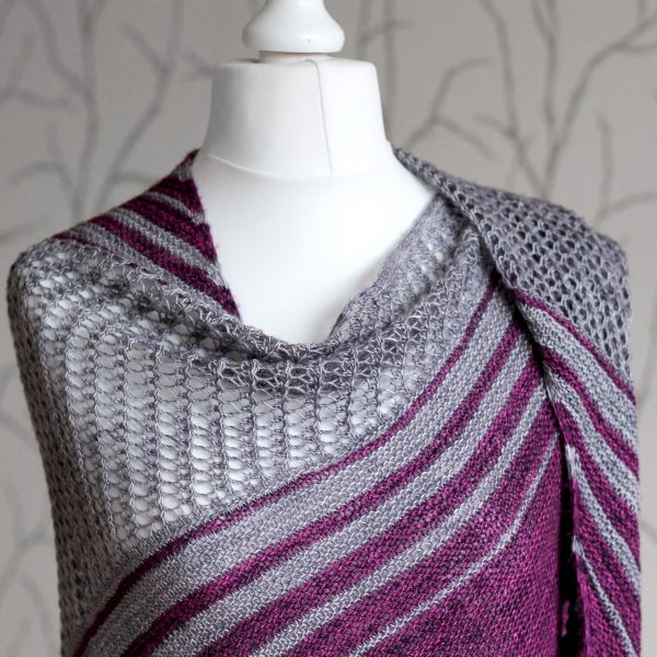 A purple and grey striped shawl with lace panels draped around a mannequin