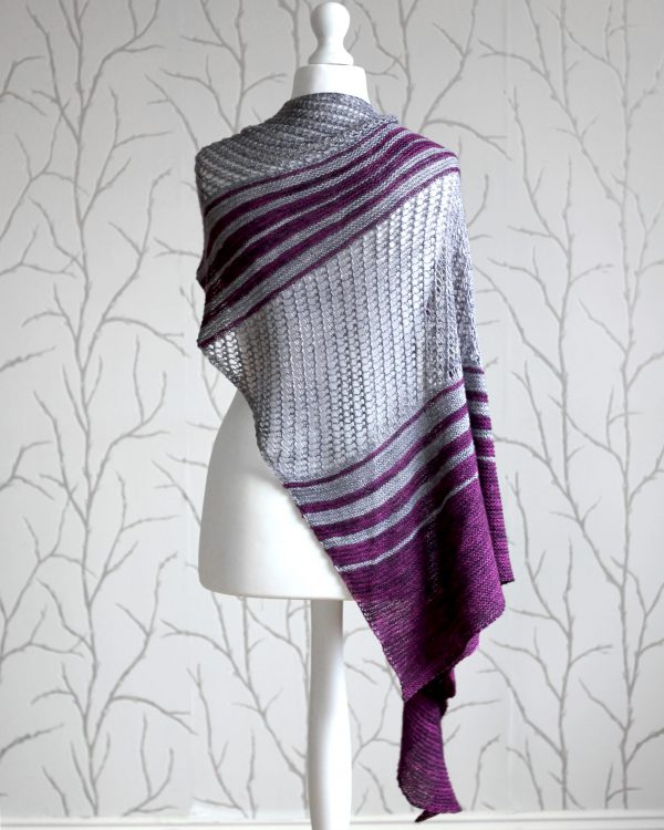 A purple and grey striped shawl with lace panels draped around a mannequin