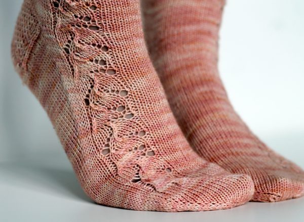 Pink socks with a floral pattern up the outside of the foot and leg