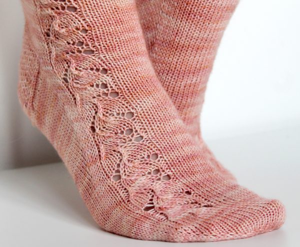 Pink socks with a floral pattern up the outside of the foot and leg