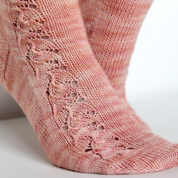 Pink socks with a floral pattern up the outside of the foot and leg