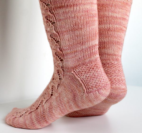 Pink socks with a floral pattern up the outside of the foot and leg