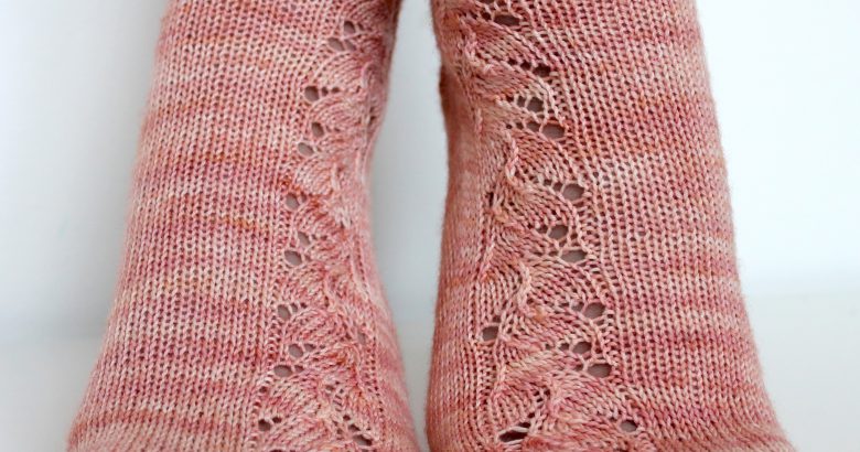 Pink socks with a floral pattern up the outside of the foot and leg