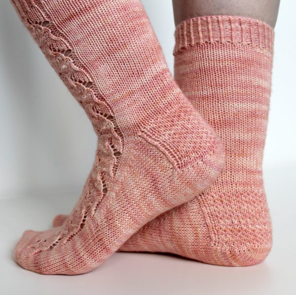 Pink socks with a floral pattern up the outside of the foot and leg