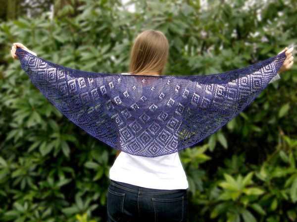 A crescent shawl with lace diamonds growing in size towards the edge