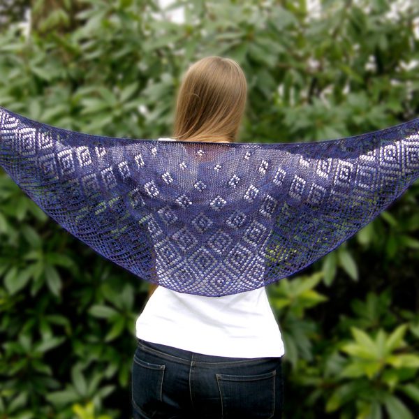 A crescent shawl with lace diamonds growing in size towards the edge