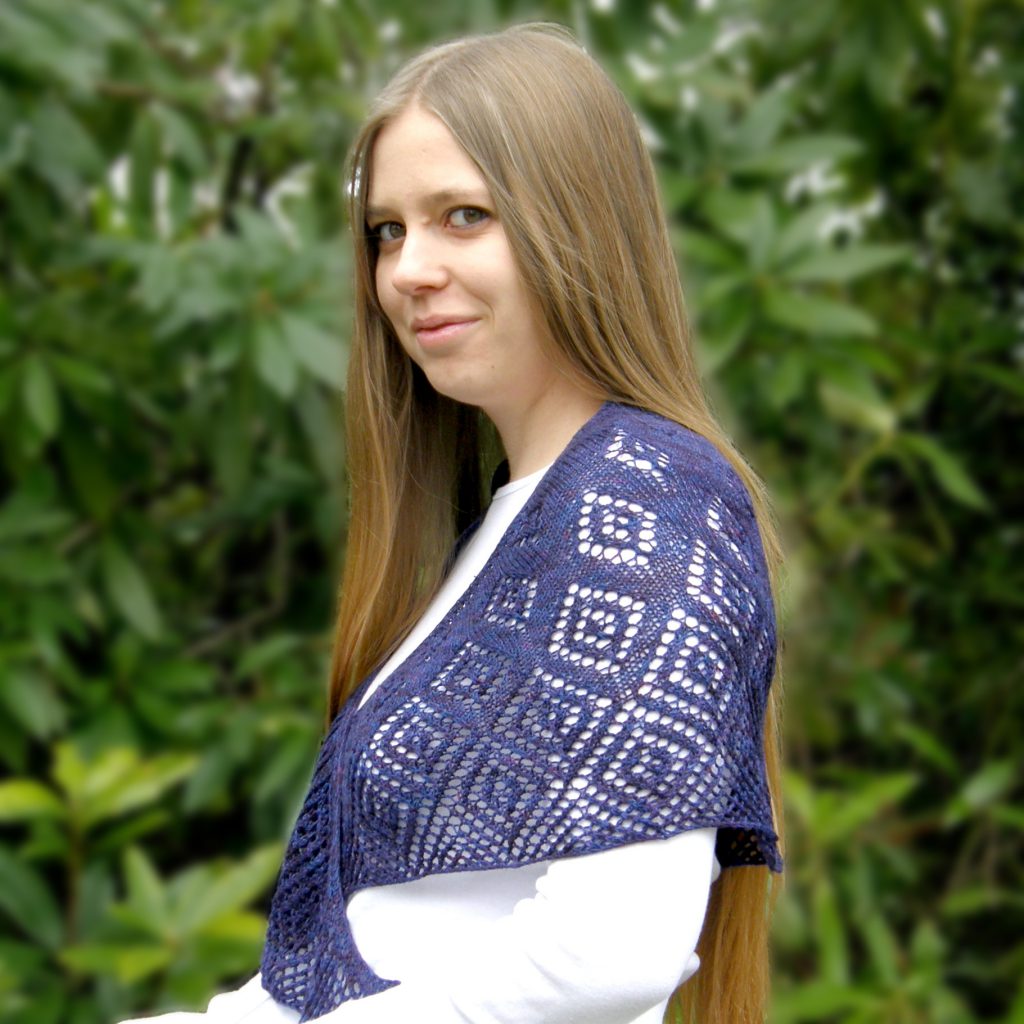 A crescent shawl with lace diamonds growing in size towards the edge