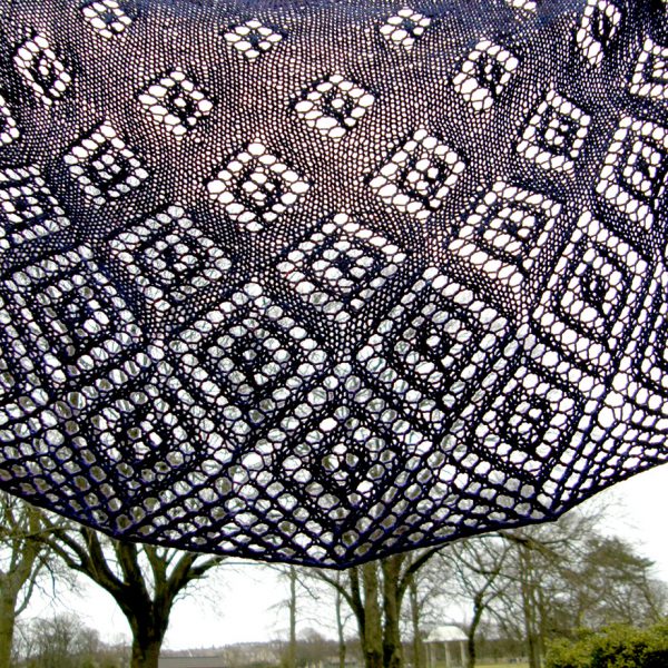A crescent shawl with lace diamonds growing in size towards the edge