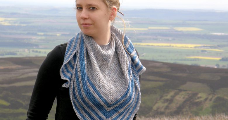 A triangular shaped shawl with a smooth striped edge
