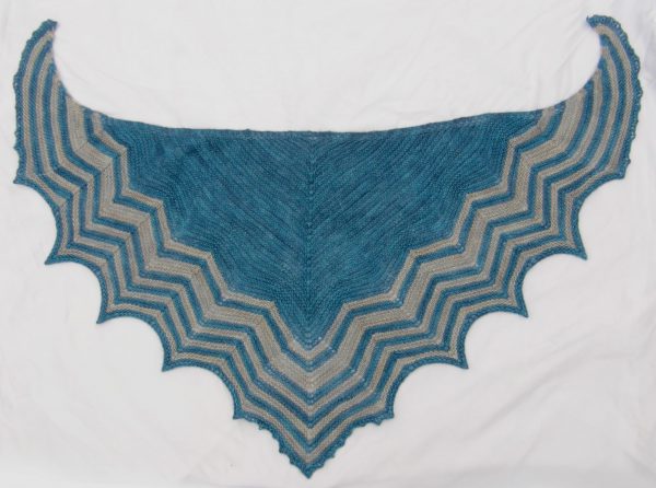 A triangular shaped shawl with a striped chevron edge
