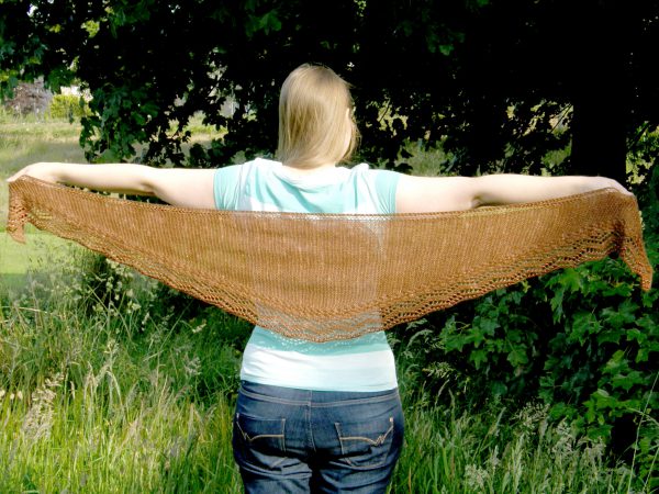 A shallow triangular shawl with a cabled, lace and beaded edge