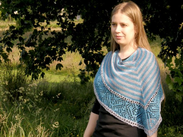 A triangular shawl with a striped stockinette body and a wide lace panel