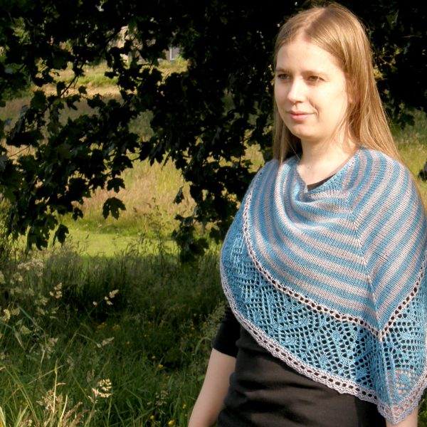 A triangular shawl with a striped stockinette body and a wide lace panel