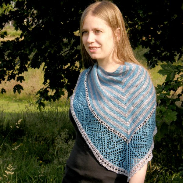 A triangular shawl with a striped stockinette body and a wide lace panel