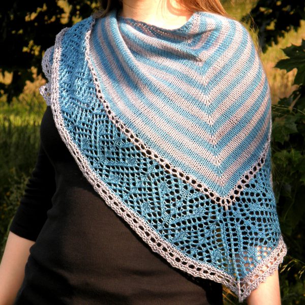 A triangular shawl with a striped stockinette body and a wide lace panel