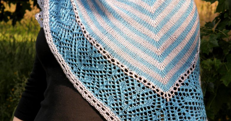 A triangular shawl with a striped stockinette body and a wide lace panel
