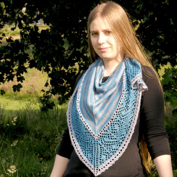 A triangular shawl with a striped stockinette body and a wide lace panel