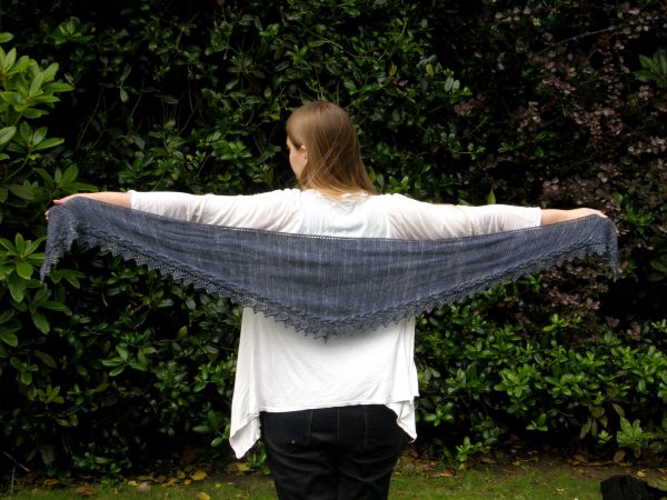 A shallow triangular shawl with a cabled, lace and beaded edge