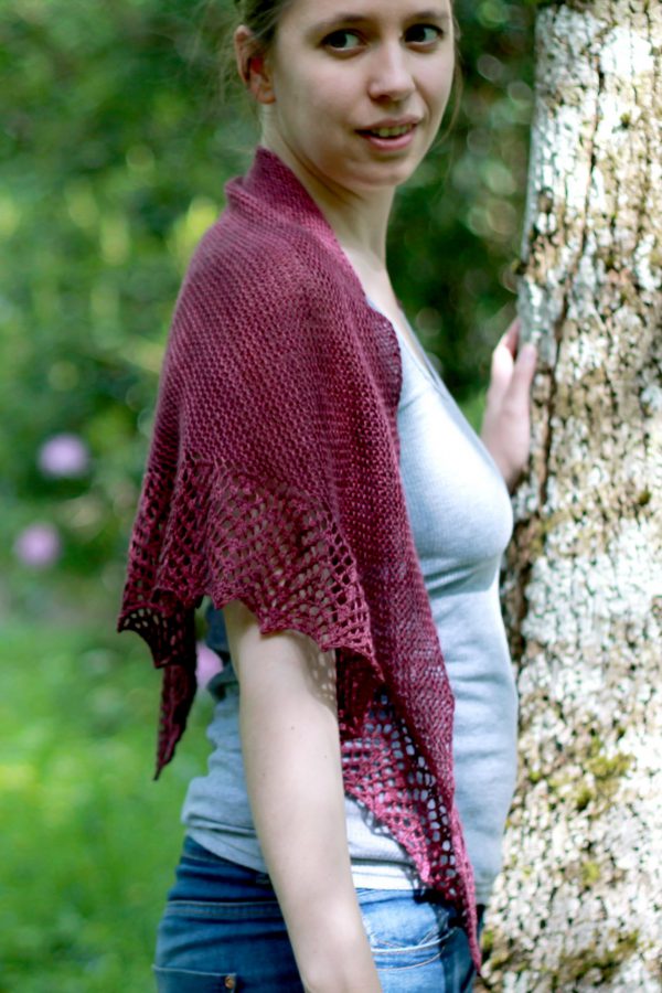 A triangular garter stitch shawl with a knitted on lace border