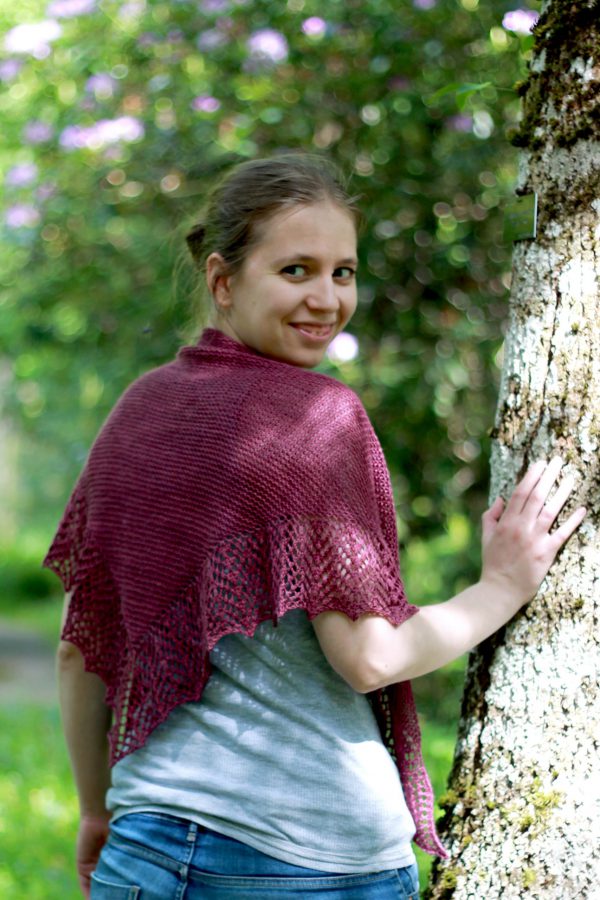 A triangular garter stitch shawl with a knitted on lace border