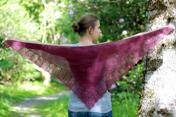 A triangular garter stitch shawl with a knitted on lace border