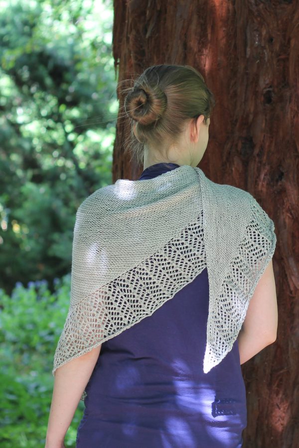 A triangular garter stitch shawl with a knitted on lace border