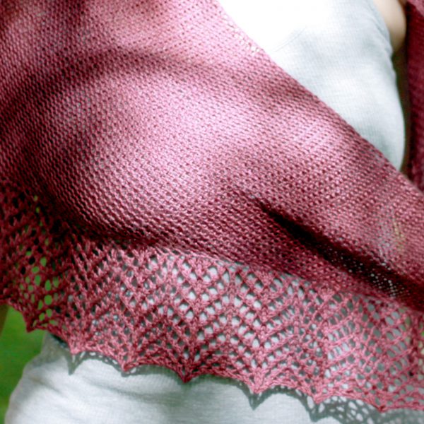 A triangular garter stitch shawl with a knitted on lace border