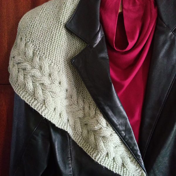 A white cabled shawl draped over a jacket