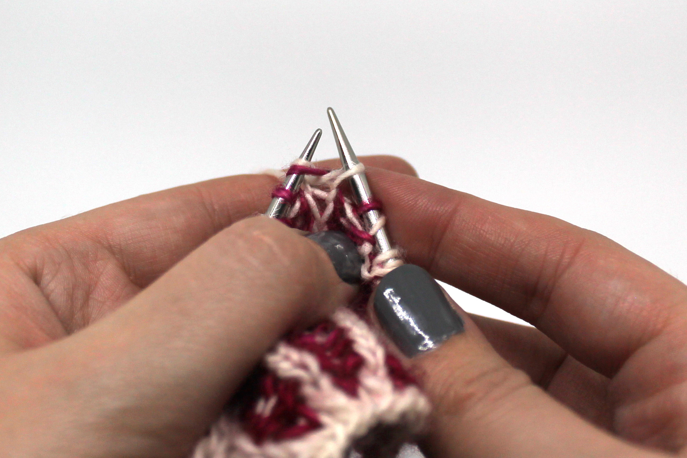 A stitch on the left hand needle with a knit stitch through it on the right hand needle