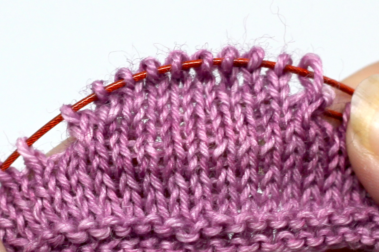 The finished short rows on the cable of a circular needle, showing the curve produced.