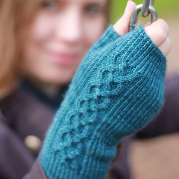 Twisted rib fingerless mitts with a large cable up the back of the hand and a narrow cable pattern that splits around the thumb